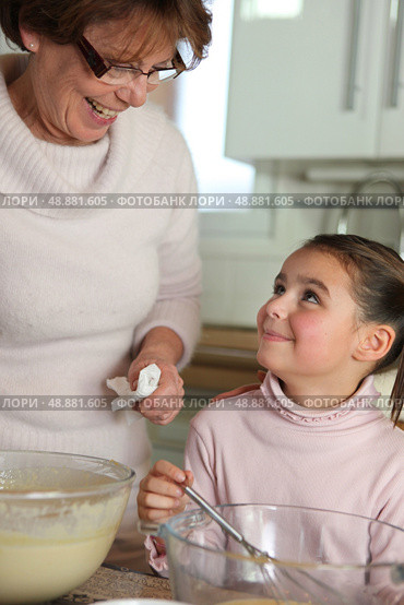 Little girl cooking with grandma. Стоковое фото, агентство Ingram Publishing / Фотобанк Лори