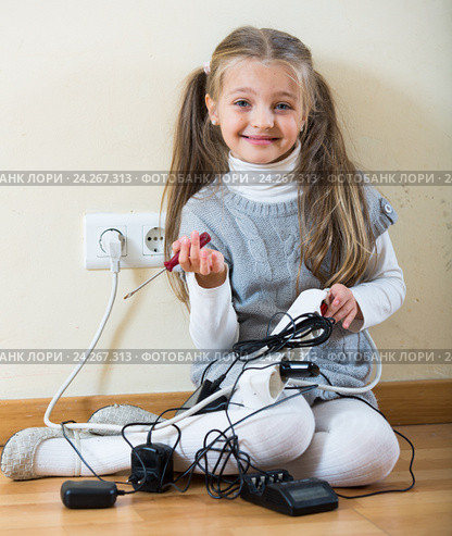 Little girl with socket extender and charging units indoors. Стоковое фото, фотограф Яков Филимонов / Фотобанк Лори