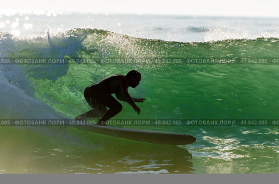 Long boarder surfing the waves at sunset in Portugal. Стоковое фото, агентство Ingram Publishing / Фотобанк Лори