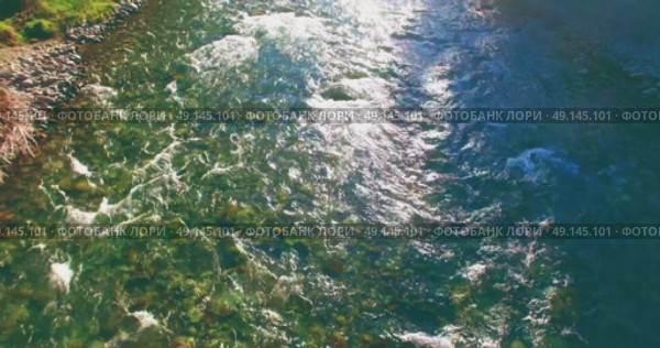 Low altitude flight over fresh fast mountain river with rocks at sunny summer morning. Стоковое видео, видеограф Александр Маркин / Фотобанк Лори