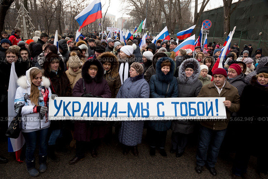 Люди держат плакат "Украина - мы с тобой!" на шествии в поддержку соотечественников на Украине в центре города Москвы (2014 год). Редакционное фото, фотограф Николай Винокуров / Фотобанк Лори