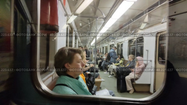 Люди едут в метро. Съемка через боковое окно вагона поезда. В общественном транспорте много людей с серьезными лицами. Московский метрополитен. Старый вагон метро. Москва, Россия - 30 мая 2022 года. People go to the subway. Shooting through the side window of the train car. There are a lot of people with serious faces on public transport. Moscow Metro. An old subway car. Moscow, Russia - May 30, 2022. Редакционное видео, видеограф Ирина / Фотобанк Лори