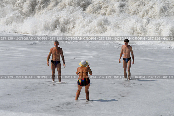 Люди на берегу моря фотографируются на память на фоне волн. Абхазия. Гагры. (2006 год). Редакционное фото, фотограф Виктор Филиппович Погонцев / Фотобанк Лори