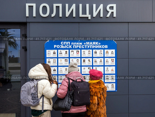 Люди у стенда с фотографиями разыскиваемых преступников (2023 год). Редакционное фото, фотограф Вячеслав Палес / Фотобанк Лори
