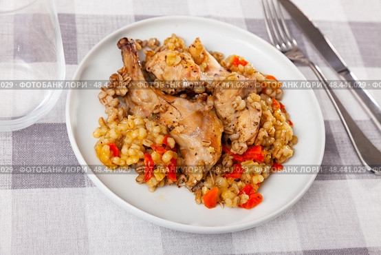 Lunch is served on plate - baked pieces of young rabbit and pearl barley. Стоковое фото, фотограф Яков Филимонов / Фотобанк Лори