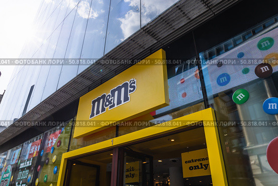 M and M London flagship storefront and logo, Leicester Square. London, UK, 2 June 2024. Редакционное фото, фотограф Zydrius Tartenis / Фотобанк Лори
