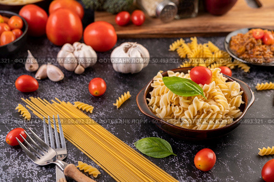 Macaroni sauteed with tomatoes and basil on a gray plate. Стоковое фото, агентство Ingram Publishing / Фотобанк Лори