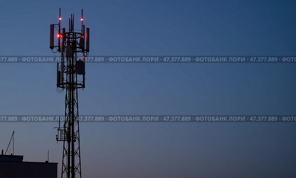 Мачта связи возвышается на фоне темнеющего неба, освещенная красными огнями. Стоковое AI-изображение, AI-художник Илья Старков / Фотобанк Лори