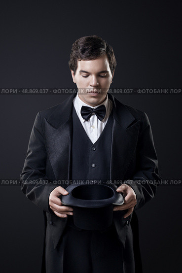 magician showing tricks with top hat isolated on dark background. Стоковое фото, агентство Ingram Publishing / Фотобанк Лори