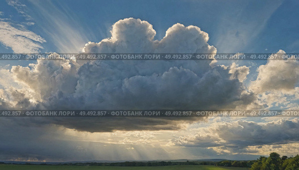 Majestic clouds billow and stretch across a vibrant sky as sunlight streams through, illuminating the rolling hills below. The scene evokes a tranquil yet powerful atmosphere Generative AI. Стоковое AI-изображение, AI-художник Юлия Петровская / Фотобанк Лори