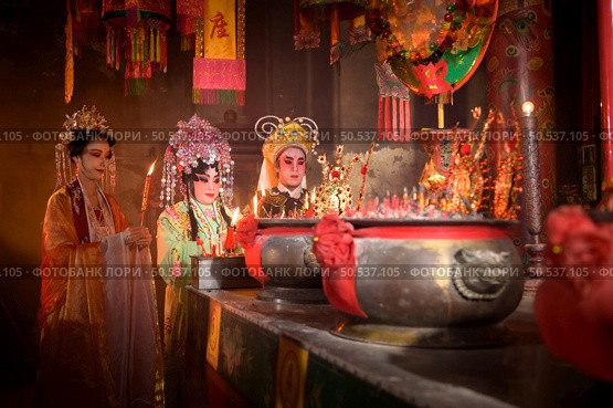 Male and female Chinese opera actors Light a candle to pray homage to the gods to enhance the prosperity for yourself on the occasion of the Chinese New Year festival. Стоковое фото, агентство Ingram Publishing / Фотобанк Лори