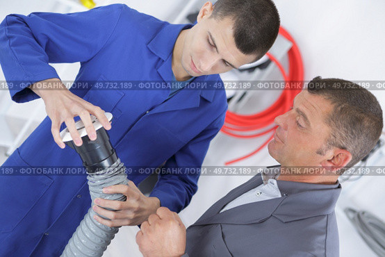male apprentice setting up ventilation system indoors. Стоковое фото, агентство Ingram Publishing / Фотобанк Лори
