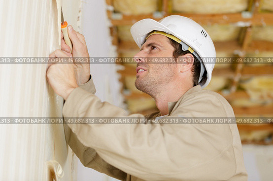 male builder removing old wallpaper for redecorating. Стоковое фото, агентство Ingram Publishing / Фотобанк Лори