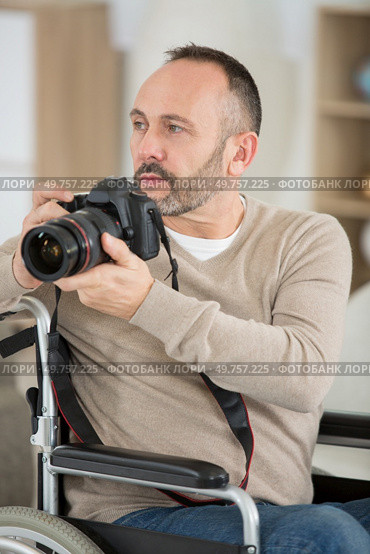 male disabled photographer holds camera in his hands. Стоковое фото, агентство Ingram Publishing / Фотобанк Лори