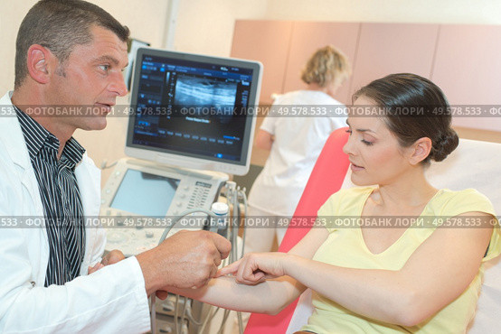 male doctor with female patient undergoing arm echography. Стоковое фото, агентство Ingram Publishing / Фотобанк Лори
