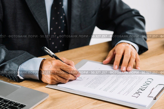 male lawyer signing contract with pen clipboard. High resolution photo. male lawyer signing contract with pen clipboard. High quality photo. Стоковое фото, агентство Ingram Publishing / Фотобанк Лори