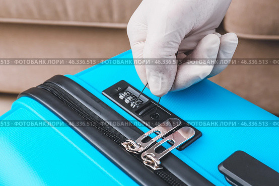 Male thief trying to open stolen suitcase, closeup. Стоковое фото, фотограф Pixel_shot / Фотобанк Лори