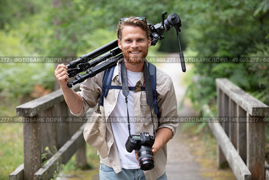 male tourists carrying a camera and tripods. Стоковое фото, агентство Ingram Publishing / Фотобанк Лори