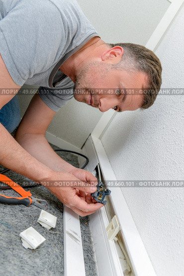 male worker repairing mains socket. Стоковое фото, агентство Ingram Publishing / Фотобанк Лори