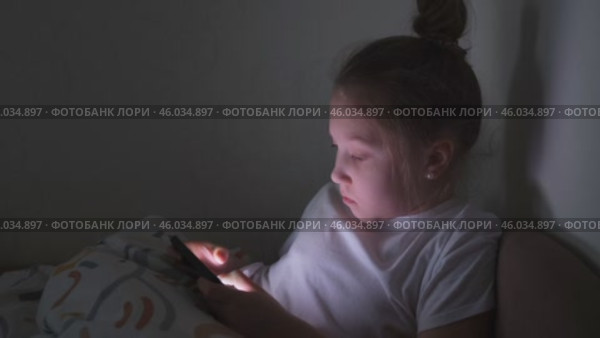 Маленькая девочка играет в мобильные игры на телефоне. Пристрастие к онлайн-видеоиграм на смартфоне. Концепция детской зависимости от технологий. Стоковое видео, видеограф Терехова Марина / Фотобанк Лори