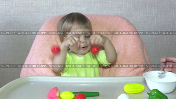 Маленького играющего ребенка кормят детской кашей. Стоковое видео, видеограф Галина Михалишина / Фотобанк Лори