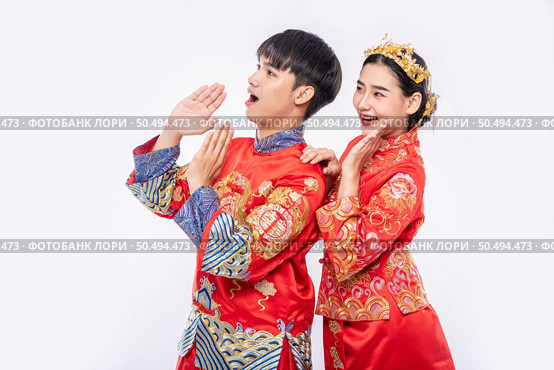 Man and woman wear Cheongsam suit Shout surprising promotion event in chinese new year. Стоковое фото, агентство Ingram Publishing / Фотобанк Лори
