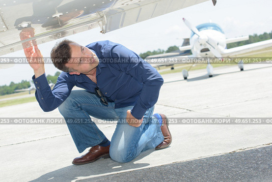 Man checking underside of aircraft. Стоковое фото, агентство Ingram Publishing / Фотобанк Лори