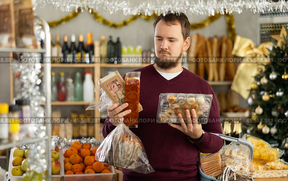 Man chooses turron, panellets and panettone. Стоковое фото, фотограф Яков Филимонов / Фотобанк Лори