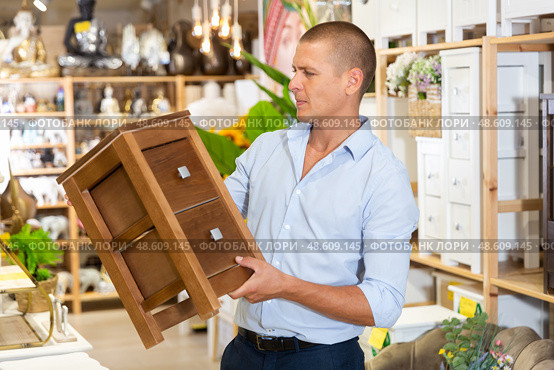 Man choosing small cabinet in store. Стоковое фото, фотограф Яков Филимонов / Фотобанк Лори