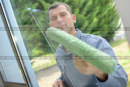 Man cleaning a window pane. Стоковое фото, агентство Ingram Publishing / Фотобанк Лори