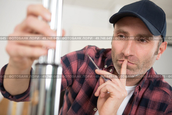 man contemplating how to assemble metal tubes. Стоковое фото, агентство Ingram Publishing / Фотобанк Лори