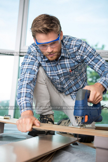 man cutting wood block with fretsaw. Стоковое фото, агентство Ingram Publishing / Фотобанк Лори