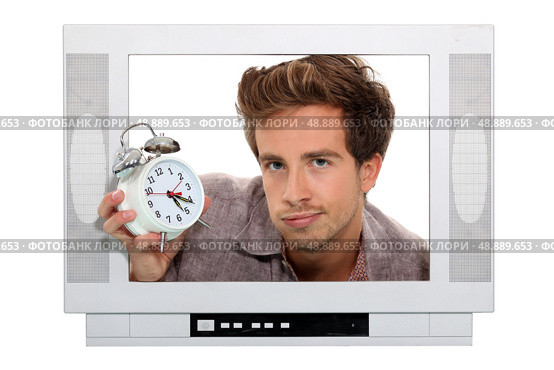 Man holding alarm clock trapped in the television. Стоковое фото, агентство Ingram Publishing / Фотобанк Лори