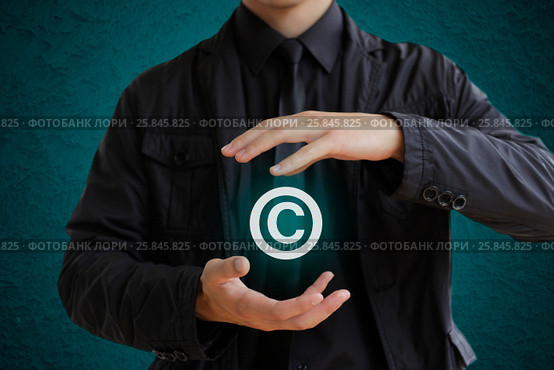 Man holding copyright symbol. Concept image for illustration of author protection or intellectual property. Стоковое фото, фотограф Плотников Дмитрий / Фотобанк Лори