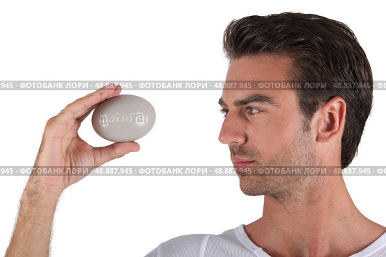 Man holding pebble in hand. Стоковое фото, агентство Ingram Publishing / Фотобанк Лори