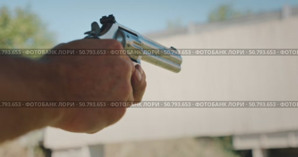 Man holding revolver aiming and firing during shooting practice at target range. Стоковое видео, видеограф Igor Tichonow / Фотобанк Лори