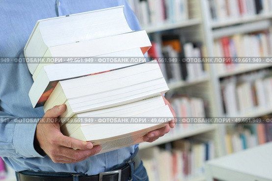 man holds a pile of books. Стоковое фото, агентство Ingram Publishing / Фотобанк Лори