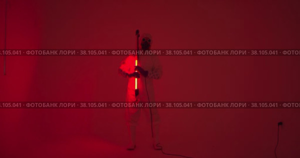 Man in protection suite marching like guard of honor caring fluorescent lamp. Стоковое видео, видеограф Aleksey Kidisyuk / Фотобанк Лори