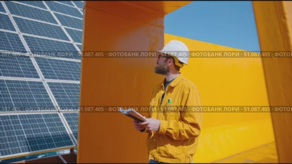 Man in safety gear observes surroundings on ship deck during bright day at sea. Стоковое AI-видео, аниматор Сергей Толмачёв / Фотобанк Лори