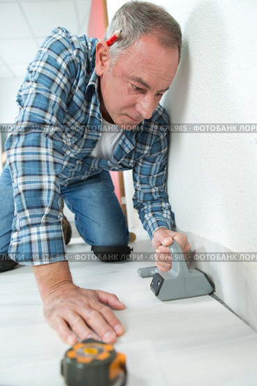 man installing light laminate flooring in a room. Стоковое фото, агентство Ingram Publishing / Фотобанк Лори