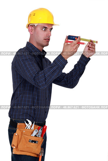Man looking at his measuring tape surprisingly. Стоковое фото, агентство Ingram Publishing / Фотобанк Лори