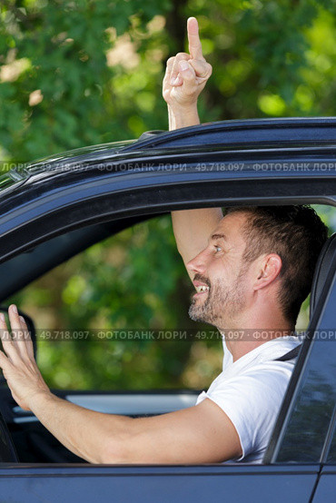 man making offensive hand gesture out of car window. Стоковое фото, агентство Ingram Publishing / Фотобанк Лори