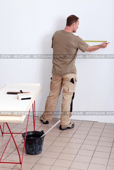 Man measuring wall. Стоковое фото, агентство Ingram Publishing / Фотобанк Лори