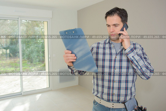 man on the phone is verifying the information. Стоковое фото, агентство Ingram Publishing / Фотобанк Лори