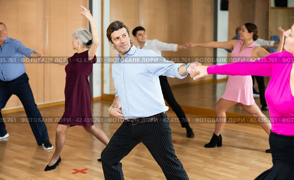 Man practicing jitterbug with female partner in dance studio. Стоковое фото, фотограф Яков Филимонов / Фотобанк Лори