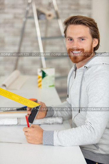 man redecorating holds a set-square. Стоковое фото, агентство Ingram Publishing / Фотобанк Лори