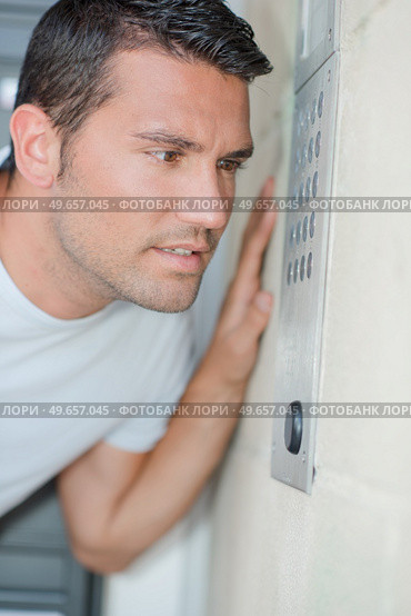 Man speaking into an intercom system. Стоковое фото, агентство Ingram Publishing / Фотобанк Лори