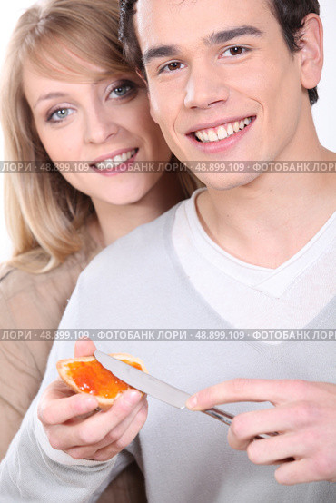 Man spreading jam onto bread. Стоковое фото, агентство Ingram Publishing / Фотобанк Лори