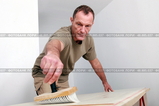 Man sweeping a wooden surface. Стоковое фото, агентство Ingram Publishing / Фотобанк Лори