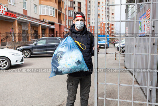 Man taking out garbage during coronavirus pandemic, it is allowed without any permission. Стоковое фото, фотограф Кекяляйнен Андрей / Фотобанк Лори